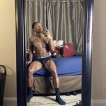 Cortez Sims Takes A Picture In A Pair Of Versace Greca Border Trunks