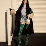 Monica Arnold Wears A Raf Simons American Letterman Jacket And Balenciaga Green Floral Lace Over The Knee Boots