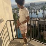 Mikey Williams Styles In A Burberry Logo Print Tee-Shirt, Ryoko Rain Paisley Mocha Shorts And Gucci Rhyton Leather Sneakers