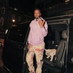Shy Glizzy Stepped Out In A 1017 ALYX 9SM Graffiti Print Drawstring Hoodie, Stone Island Heritage Camo Pants And Undercover × Nike Air Force 1 Low SP Grey Sneakers
