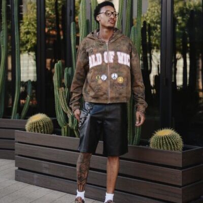 Young man in hoodie and shorts by cacti