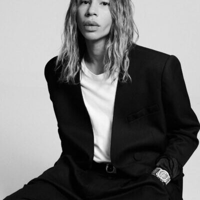 Black-and-white portrait of long-haired person in suit