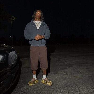 Person in hoodie and sneakers at night