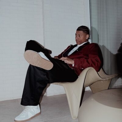 Person in red blazer lounging in modern chair