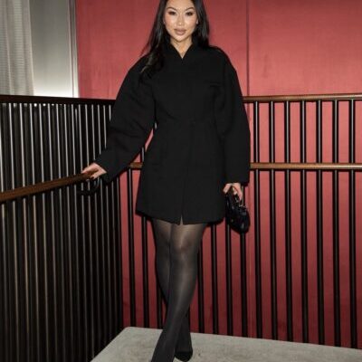 Woman in black coat and heels by railing