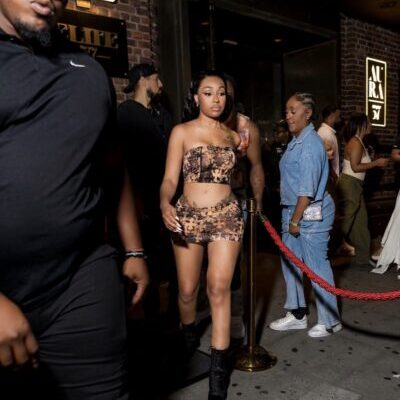 Woman in animal-print outfit exiting nightclub past rope